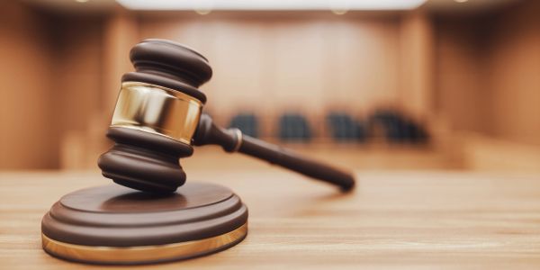 Judge's gavel on a wooden table in courtroom.