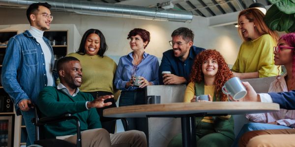 Diverse group of people enjoying coffee and laughing together.