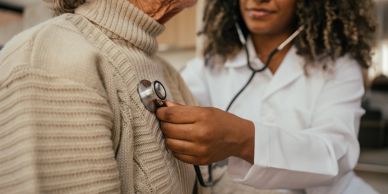 Doctor using a stethoscope on a patient.