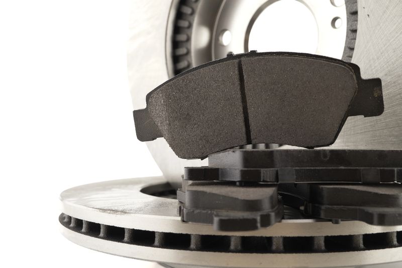 Close-up shot of a car brake rotor and brake pads, highlighting automotive maintenance and repair.