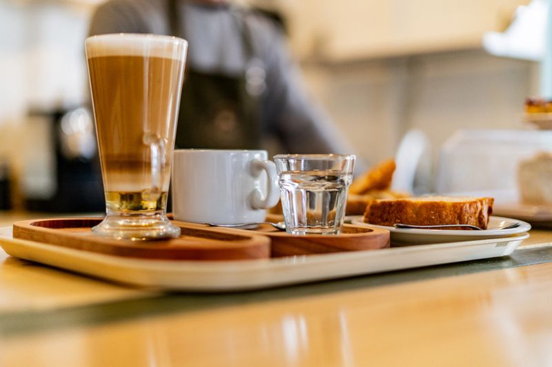 Close-up of a tray with a cup of coffee and a glass of water on a table in a coffee shop