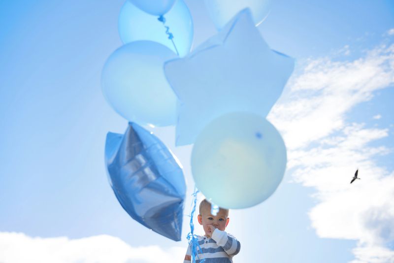 Adorable toddler playing with colorful balloons during a joyful outdoor photo shoot