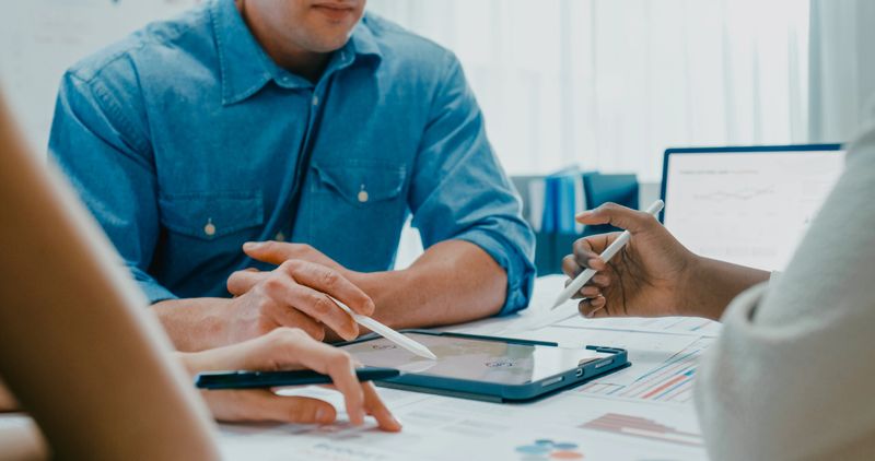 Cloesup of diverse finance team business meeting discussing investment strategy and financial report presentation on laptop at modern office. Marketing strategy analysis, financial consultant concept.