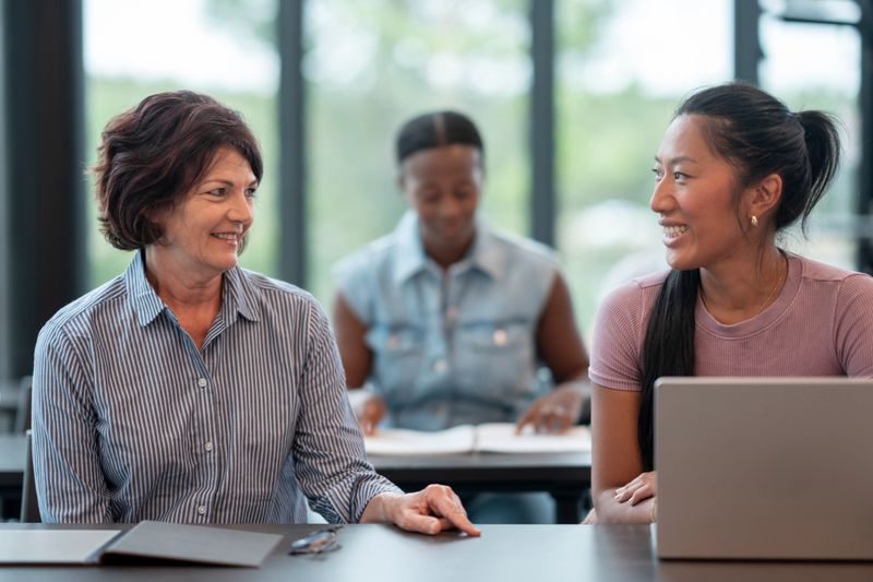 A multicultural adult educational setting, showcasing collaboration among students engaged in learning with confidence and warmth in an academic environment.