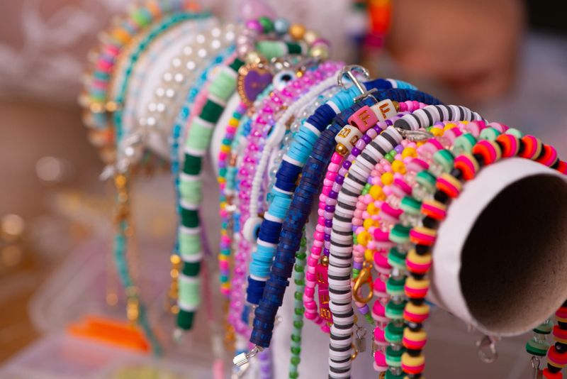 A close-up view of multiple colorful handmade beaded bracelets neatly arranged on a display holder. The bracelets feature vibrant designs, patterns, and textures, showcasing creativity, fashion, and craftsmanship. Perfect representation of jewelry-making, artisan design, and trendy fashion accessories.