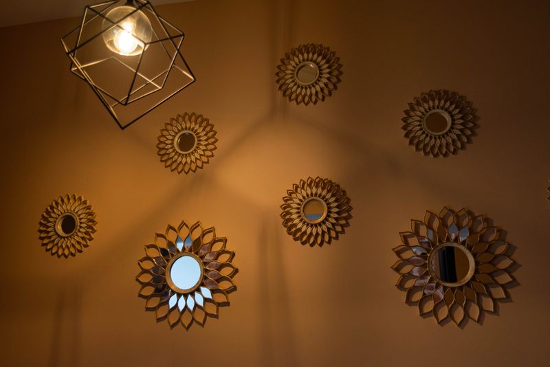 A stylish interior wall design featuring geometric patterns and circular mirrors. the warm lighting enhances the artistic arrangement, creating a modern and elegant atmosphere.