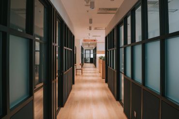 Modern office hallway with glass and wooden elements.