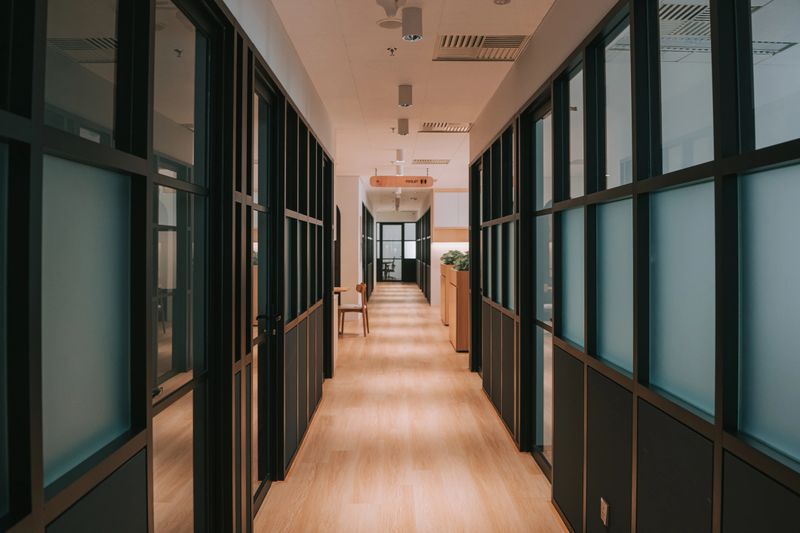 Contemporary office hallway featuring frosted glass walls, clean design, and natural lighting. The space reflects modern workplace architecture, offering a professional environment. Kuala Lumpur, Malaysia.