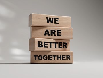 Stacked wooden blocks with the phrase 'We Are Better Together'.