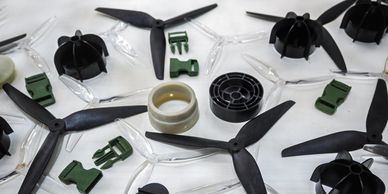 Various drone propellers and plastic components laid out on a table.