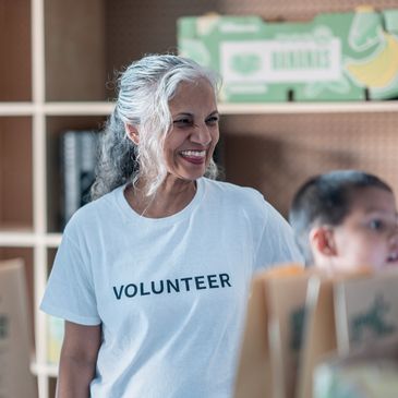 Smiling volunteer woman helping in a community service setting.