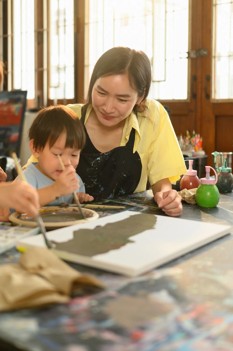 Parent and child share a bonding moment while exploring colors and creativity in an early childhood art class.