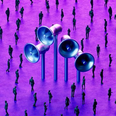 A group of people surrounding large blue megaphones on a purple floor.