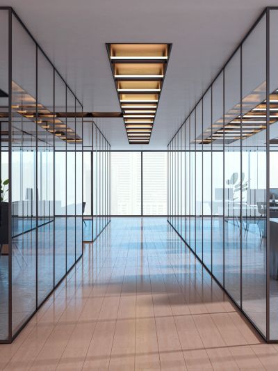 Modern office hallway with glass walls and wooden ceiling lights.