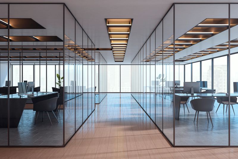 Contemporary empty office interior with glass partitions, stylish furniture and city view in background. Corporate workspace concept. 3D Rendering