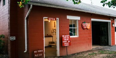 Entrance of a rustic building with signage about payment and pets.