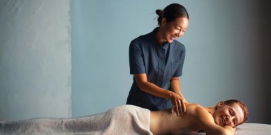Woman getting a massage from a smiling therapist.