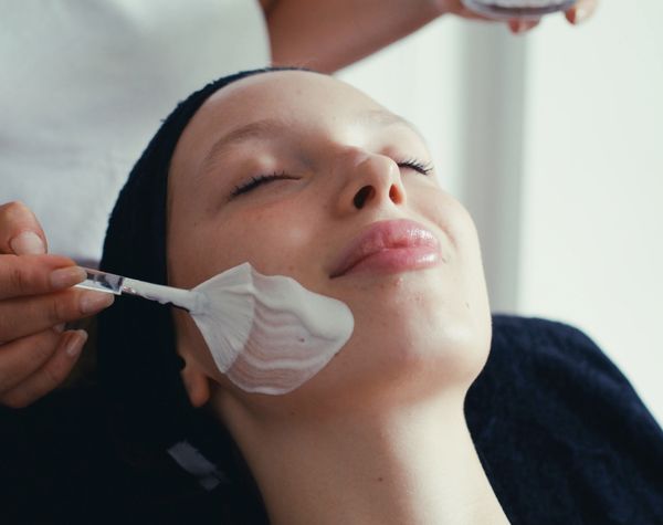Woman receiving a relaxing facial mask treatment at a spa.