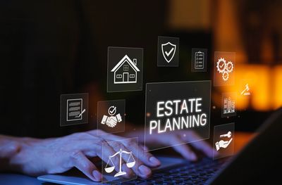 Hands typing on a laptop with digital estate planning icons floating above.