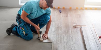 Worker installing wooden flooring.