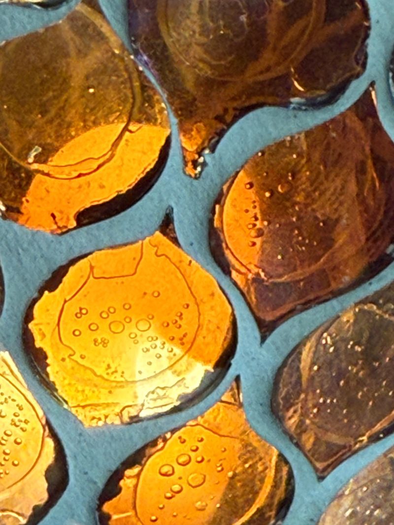 Beautiful amber glass panels create intricate patterns reflecting light and showcasing unique textures in soft natural light.