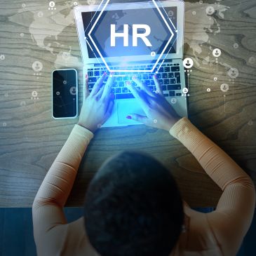 Person typing on laptop with HR (Human Resources) digital interface.