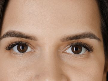 Close-up of a woman's brown eyes and well-groomed eyebrows.
