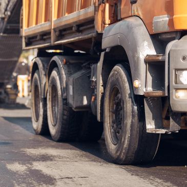 Close-up of a dirty truck's wheels and bodywork.