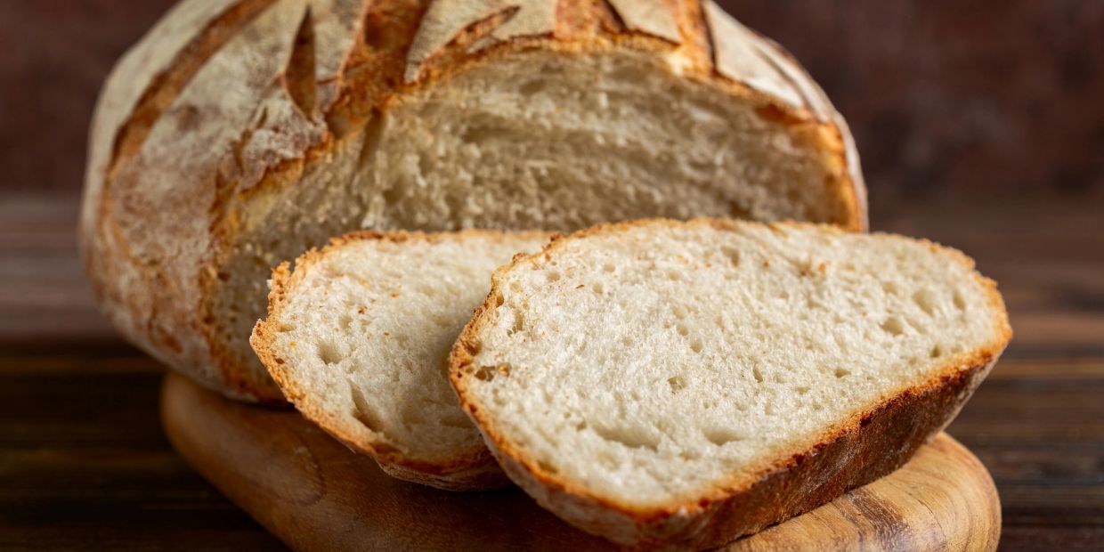 Freshly sliced rustic bread on a wooden board.