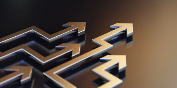 Shiny golden arrows pointing upward on a dark surface.