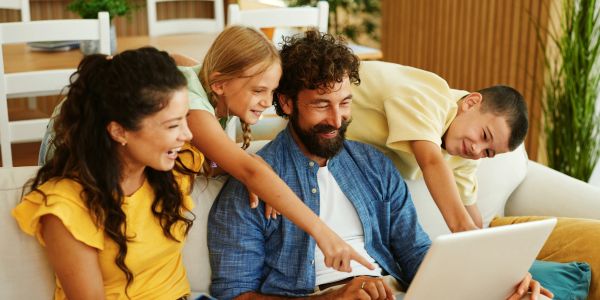 Happy family watching something on a laptop.