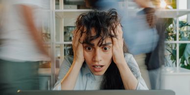 A shocked woman looking at her laptop.