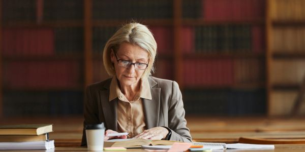 Woman reading a book in a library.