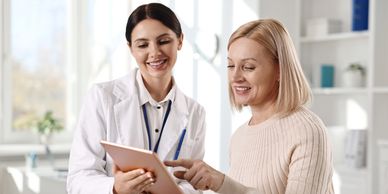 Doctor and patient discussing tablets in clinic.