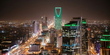 Downtown Riyadh at night from the sky with the buildings lit up.