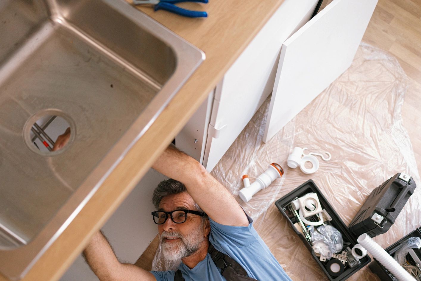 Plumber working under a sink in Mandeville LA.