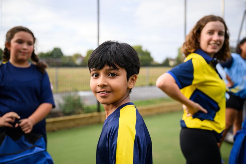 Grassroots women and girls cricket team practicing at urban club