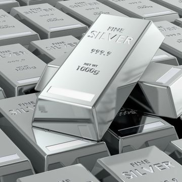 Shiny silver bars stacked with one prominently displayed on top.