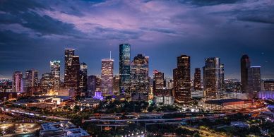 City skyline at dusk with illuminated buildings.