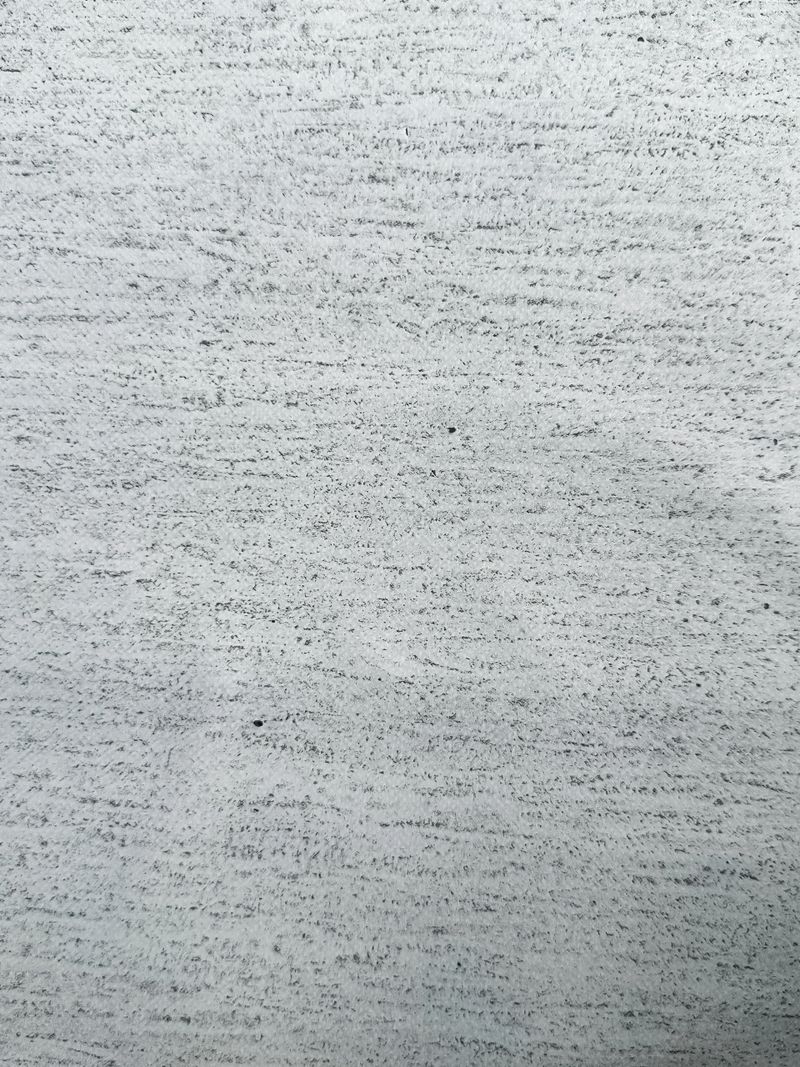 Close-up of light gray concrete with rough texture, horizontal striations, and small pits—ideal for architectural, construction, or material design reference.