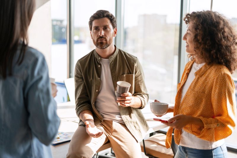 Business colleagues enjoying a coffee break while discussing project strategies during a productive meeting in a modern office environment, fostering teamwork and collaboration