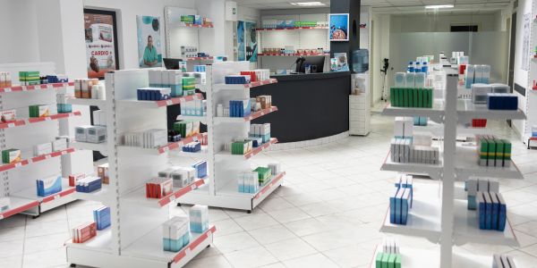 Interior of a modern pharmacy with stocked shelves.
