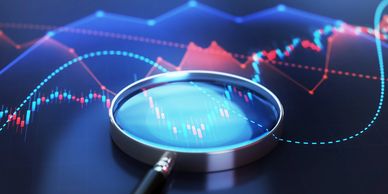 Magnifying glass over financial data charts.