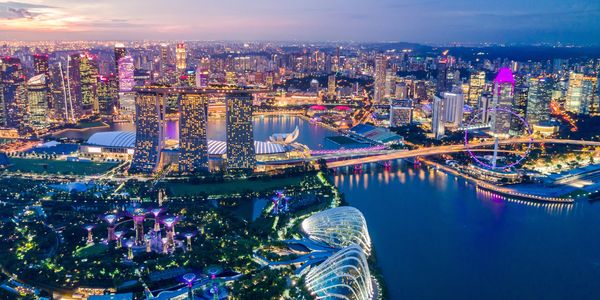 Night view of Singapore city with illuminated buildings and waterfront.