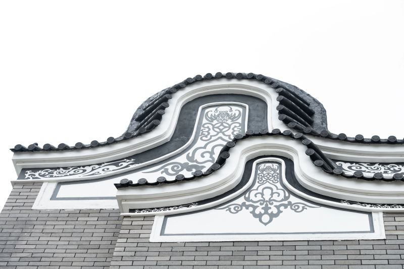 an ornate gable of a traditional Chinese building showcases intricate black-and-white patterns and curved roof tiles