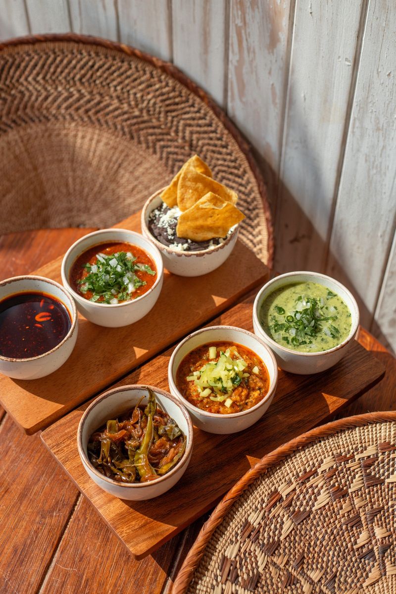 Mexican black bean dip, mojo rojo sauce and peanut chili dip  in sunny Tulum restaurant