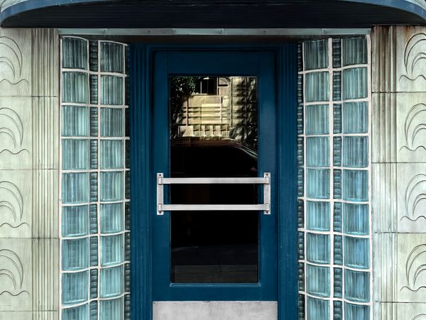 Blue door with glass panels and decorative tiled walls.