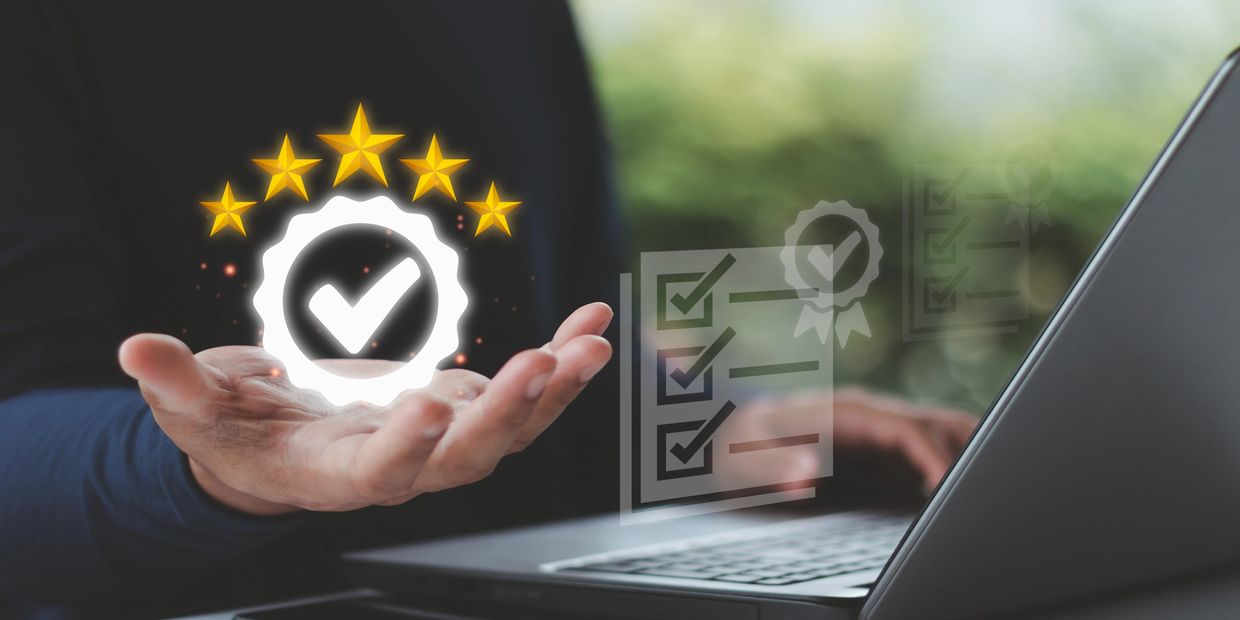 Hand holding a glowing quality check icon with five stars.