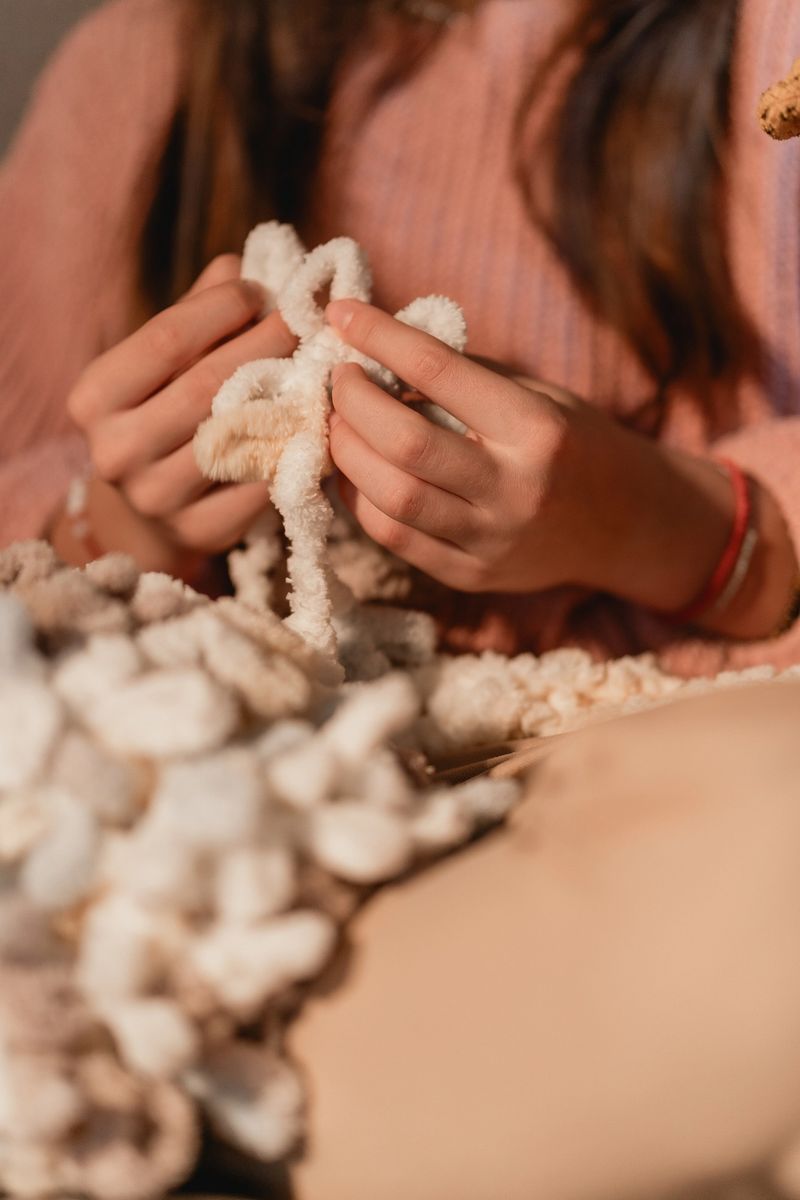 Close-up of person work on a chunky knit blanket, soft texture and warm atmosphere, perfect for cozy lifestyle content and creative projects. The image evokes comfort, creativity, and relaxation.
