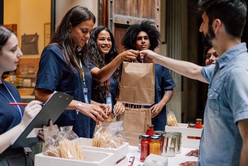 Volunteers participate in a food relief program, ensuring that canned and packaged items are prepared for distribution.
